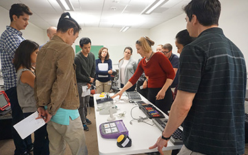 A staff member gives a presentation on assistive technology to a group of visitors.