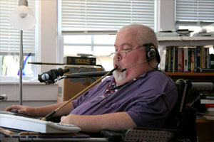 Guy Thomas, a disability right's activist and wheelchair user, typing with the use of assistive technology, a mouth stick.Guy was Board chairman at the Center for Accessible Technology.