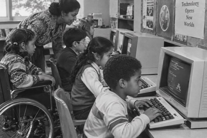 Children with disabilities use computers with support from an instructor.