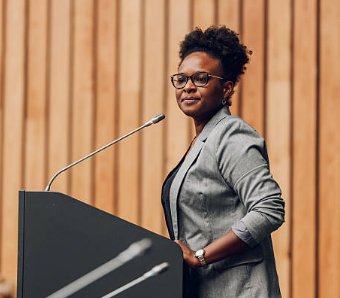 A woman speaking at a podium with a microphone